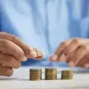 a person stacking coins on top of a table